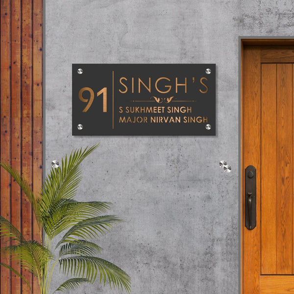 Close-up of gunmetal grey mild steel nameplate showing laser-cut lettering and finish